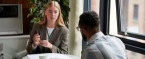 two persons sitting at a table talking